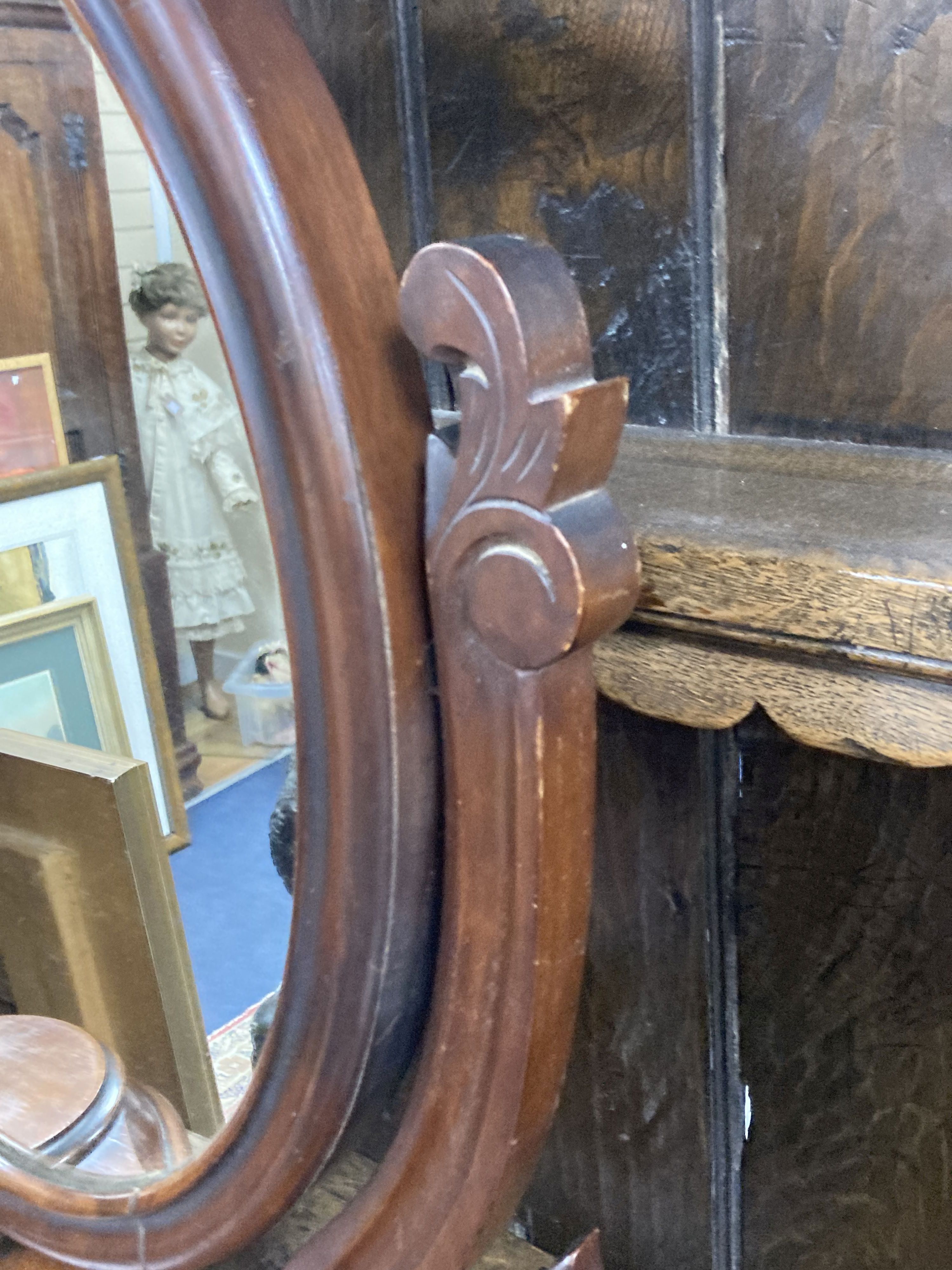 A Victorian mahogany toilet mirror of oval form above a raised platform with twin lidded compartments, width 63cm, height 71cm